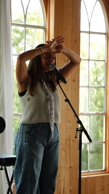 A worship leader singing with hands lifted at a Tend gathering
