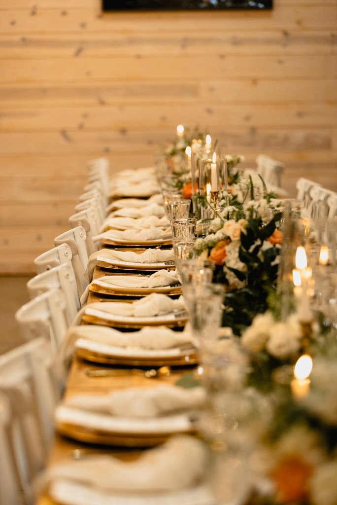 A long candlelit dinner table set with gold chargers, linen napkins and flowers at an A Place for Family vision night